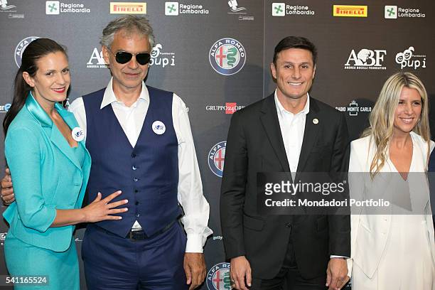 Italian singer Andrea Bocelli and Argentinian team manager and former player Javier Zanetti posing with their wives during the press conference for...