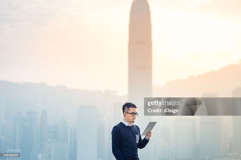 Smart man using digital tablet in urban city