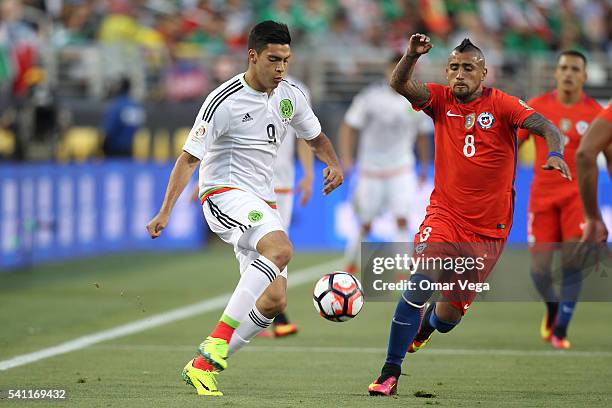 Raul Jimenez of Mexico drives the ball as Arturo Vidal of Chile defends during a Quarterfinal match between Mexico and Chile at Levi's Stadium as...