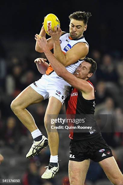 Stephen Coniglio of the Giants marks infront of Matthew Leuenberger of the Bombers during the round 13 AFL match between the Essendon Bombers and the...