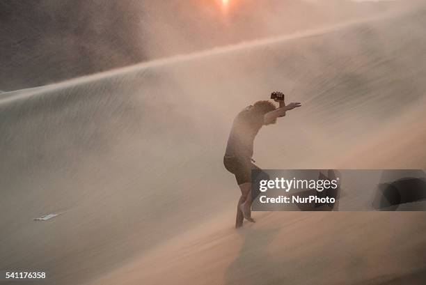 Man climbs on the top of Dune 7 near Walvis Bay, Namibia.
