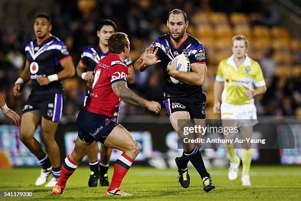 Simon Mannering of the Warriors fends against Jake Friend of the Roosters during the round 15 NRL match between the New Zealand Warriors and the...