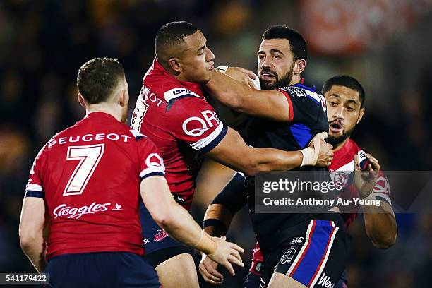 Ben Matulino of the Warriors fends against Sio Siua Taukeiaho of the Roosters during the round 15 NRL match between the New Zealand Warriors and the...