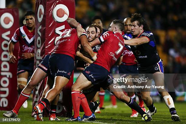 Simon Mannering of the Warriors is stopped at the line by Sio Siua Taukeiaho and Jackson Hastings of the Roosters during the round 15 NRL match...