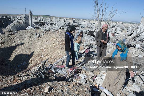 On their return to their home in Kobani, Syria, a family looks to recover some of their possessions amongst the debris caused by allied bombing. A...