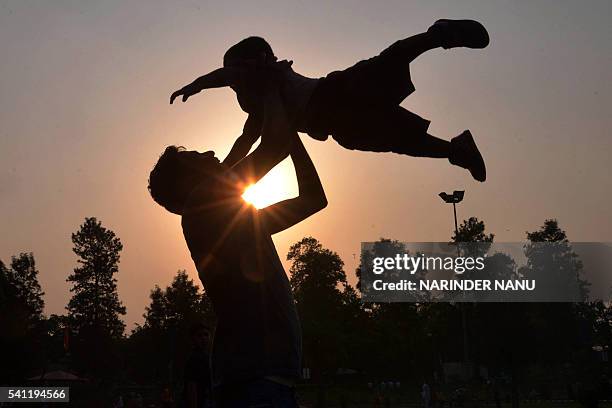 Indian father Shailesh throws up his son, Harish, at a park in Amritsar on June 19 on Father's Day, a day observed in many countries to celebrate...