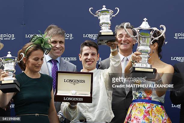 Italian jockey Cristian Demuro poses with his trophy after coming in first on La Cressonniere during the 167th "Prix de Diane", a 2100-metre flat...