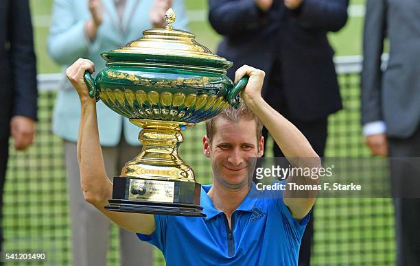 Florian Mayer of Germany lifts the winners cup after winning the final match of the Gerry Weber Open against Alexander Zverev of Germany at Gerry...