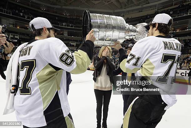 Sidney Crosby and Evgeni Malkin of the Pittsburgh Penguins carry the Stanley Cup to Nathalie Lemieux after defeating the San Jose Sharks in Game Six...