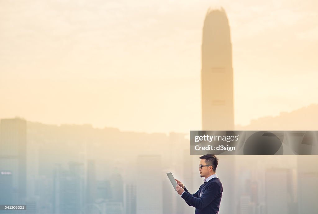 Smart businessman using digital tablet in city