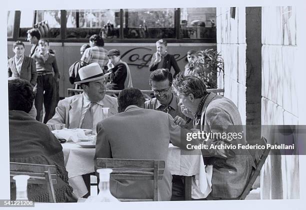 The American movie director John Huston tucks into a bowl of spaghetti as he dines with the cast of Beat the Devil. The film stars Robert Morely ,...