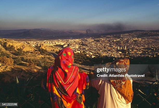 two women in head scarves overlooking city - air pollution stock pictures, royalty-free photos & images