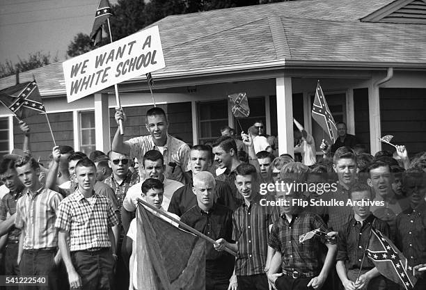 Crowd of teenage boys protest against school integration and wave Confederate flags in Montgomery, Alabama in 1963.