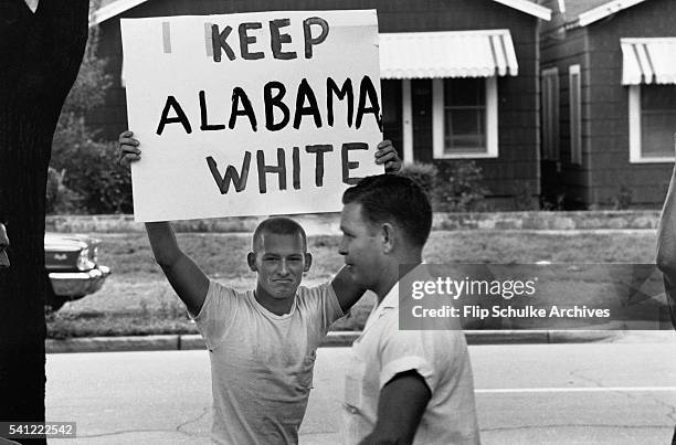 Teenager and an adult during a protest against school integration in Montgomery, Alabama, USA, 1963. The youth holds a placard reading 'Keep Alabama...