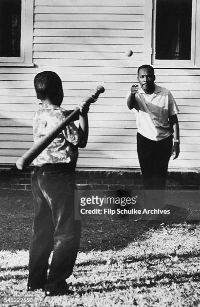Martin Luther King Jr. Throws a baseball for his son to hit in the backyard of their Atlanta home.