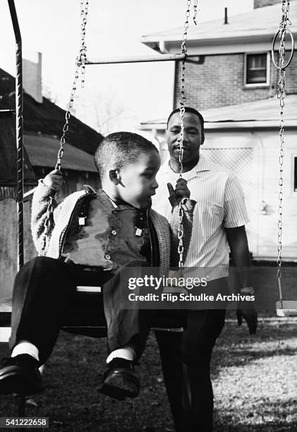 Martin Luther King Jr. Pushes his son Dexter on a swing in the backyard of their Atlanta home.