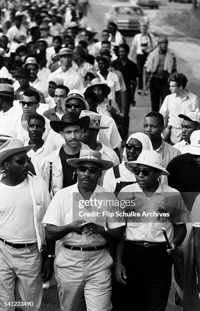 Martin Luther King Jr., James Meredith, and Dick Gregory walk together in the March Against Fear through rural Mississippi.