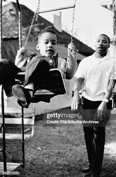 Martin Luther King Jr. Pushes his son Dexter on a swing in the backyard of their Atlanta home.