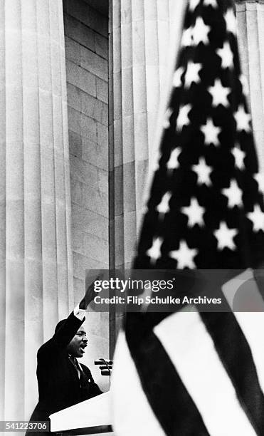 Pictured between the vast columns of the Lincoln Memorial and an American flag, Martin Luther King Jr. Delivers his historic keynote speech "I Have a...