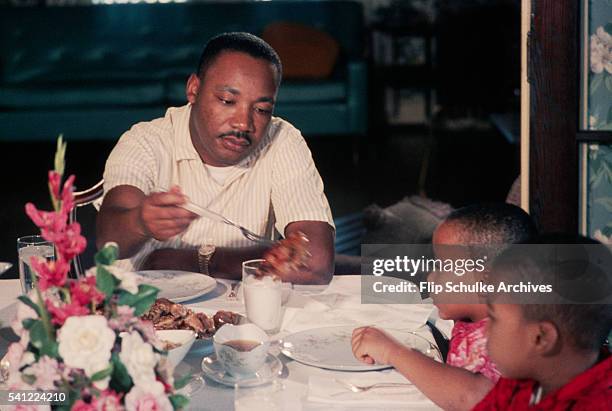 Martin Luther King Jr. Serves pieces of chicken to his young sons Marty and Dexter at Sunday dinner.