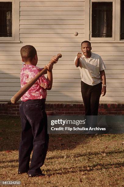 Martin Luther King Jr. Throws a baseball to his son Marty in their backyard.