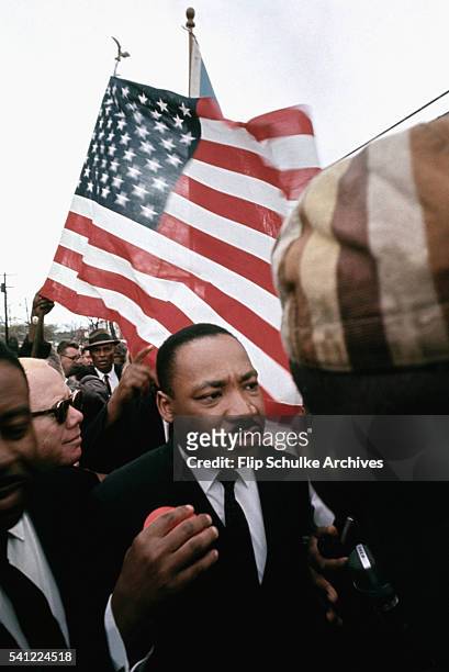 Martin Luther King Jr. Marches with other religious leaders and activists past Browns Chapel in Selma, Alabama, during the second attempted march to...