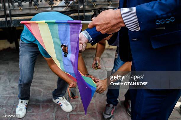 Turkish nationalists burn a rainbow flag during a rally staged by the LGBT community on Istiklal avenue in Istanbul on June 19, 2016. Turkish riot...