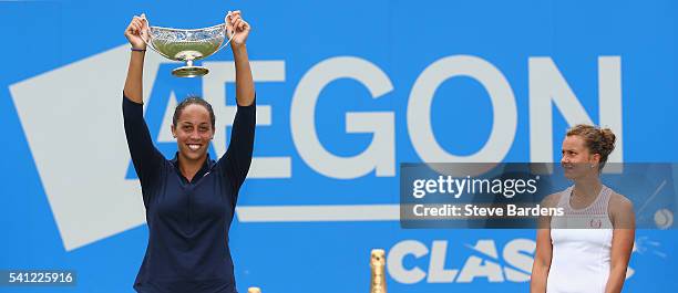 Madison Keys of United States lifts the Maud Watson trophy as Barbara Strycova of Czech Republic looks on after the Women's Singles Final on day...