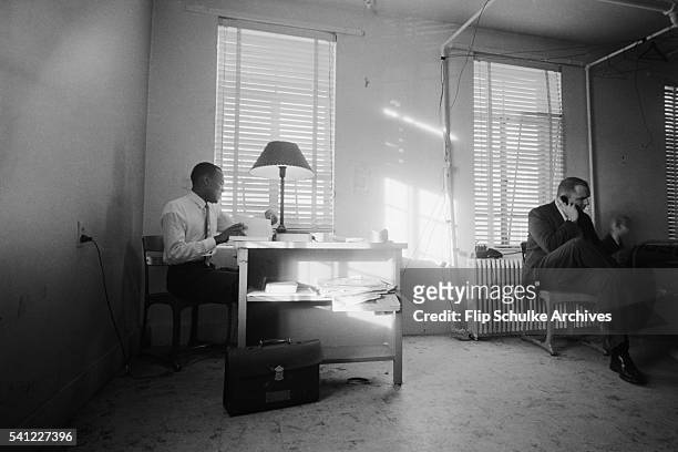 James Meredith, the first African American student at the University of Mississippi, studies in his dormitory room with an FBI agent on the telephone...