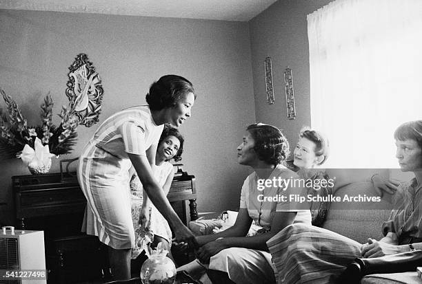 Women consol Myrlie Evers after the assassination of her husband Medgar Evers. Medgar Evers was the president of Mississippi's chapter of the NAACP.