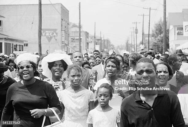 Mourners march and sing through Jackson, Mississippi in a funeral procession for slain civil rights leader Medgar Evers.