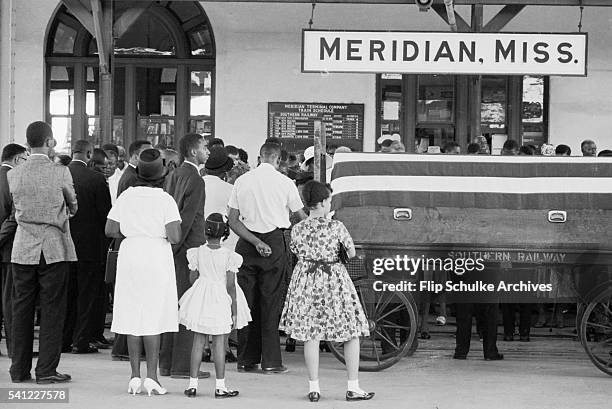 Mourners stand solemnly beside the casket of civil rights leader Medgar Evers at the Meridian train station.