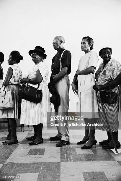 African American citizens wait in line to register to vote in Alabama after the enactment of the Voting Rights Act.