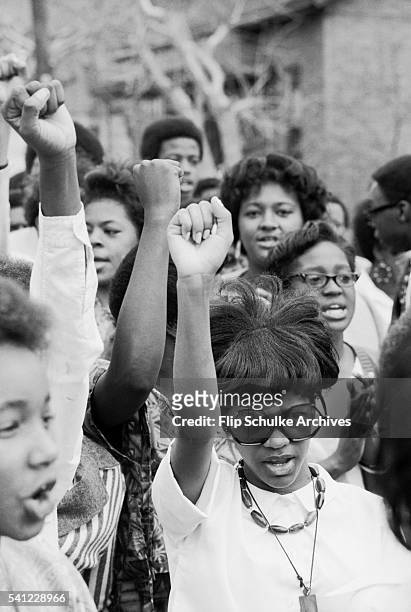 Young women raise their fists in the Black Power salute at a civil rights rally, circa 1968.