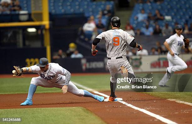 Brandon Belt of the San Francisco Giants gets safely to first base ahead of first baseman Logan Morrison of the Tampa Bay Rays off of his single...