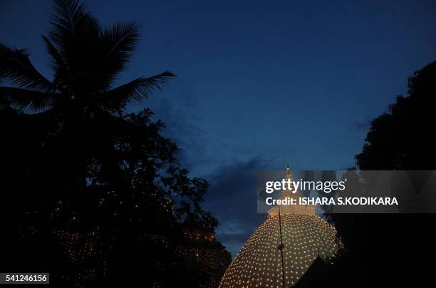 An illuminated buddhist temple is pictured in Kelaniya on June 19, 2016 during Poya, a full moon religion festival. Sri Lanka celebrates "Poson", a...