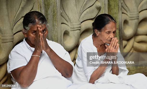 Sri Lankan Buddhists pray in Kelaniya temple on June 19, 2016 during Poya, a full moon religion festival. Sri Lanka celebrates "Poson", a Buddhist...