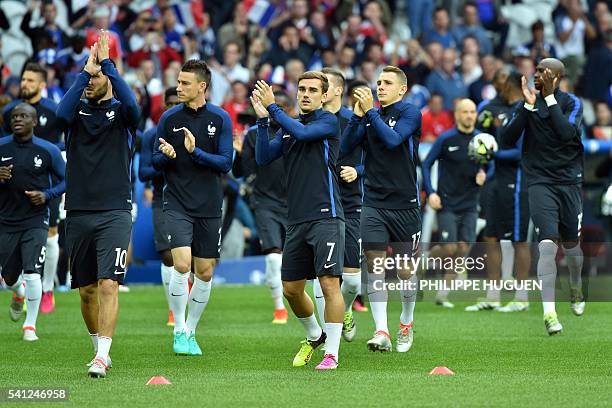 France's forward Antoine Griezmann applauds as he walks with teammates on the pitch prior to the Euro 2016 group A football match between Switzerland...