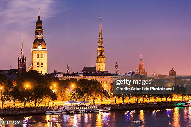 the daugava river with the bell-tower of st. savior anglican church, the bell-tower of the evangelical lutheran cathedral, the bell-tower of st. peter church and the latvian academy of science building - riga stockfoto's en -beelden