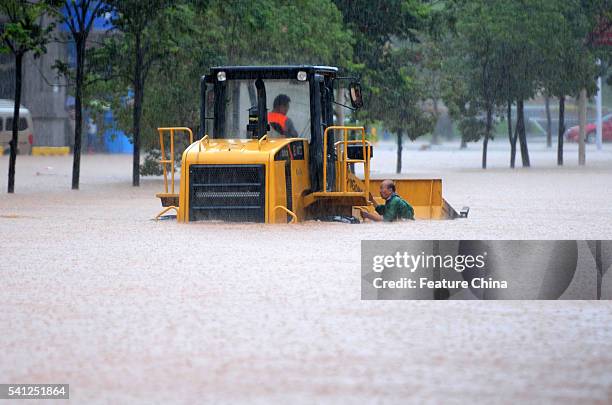 Rescuer drives an engineering vehicle in the flooding in Jiujiang in central China's Jiangxi province Sunday June 19, 2016. Since June 13,a week of...