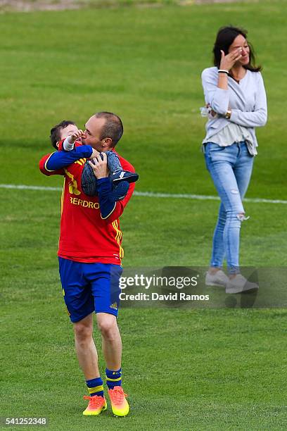 Andres Iniesta of Spain kisses his son Paolo Andrea as his wife Anna Ortiz reacts on the background after a training session at Complexe Sportif...