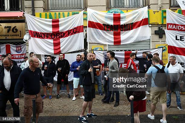 Fans drink and gesture next to England supporters flags hung outside bars ahead of tomorrow's England v Slovakia Euro 2016 Group B match, on June 19,...