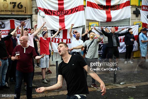 Fans drink and gesture next to England supporters flags hung outside bars ahead of tomorrow's England v Slovakia Euro 2016 Group B match, on June 19,...