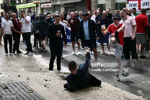 Man lies on the ground after falling over as supporters play football while they gather ahead of tomorrow's England v Slovakia Euro 2016 Group B...
