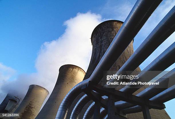 cooling towers and pipes at geothermal power plant - geothermische centrale stockfoto's en -beelden