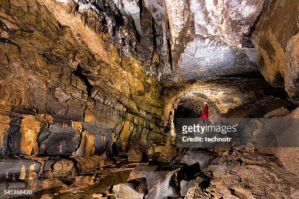 caver posing in the beautiful colorful cave - geoloog stockfoto's en -beelden