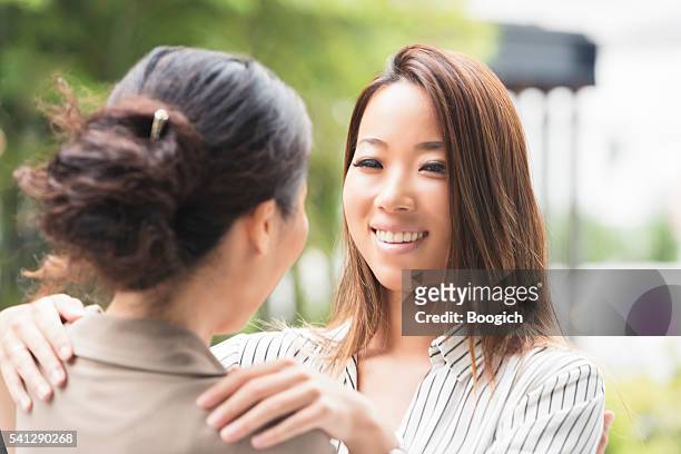 millennial japanese daughter greets her mother outdoors kyoto japan - homecoming 個照片及圖片檔
