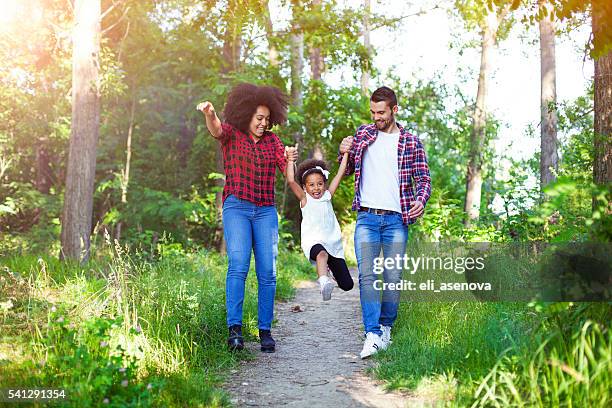 happy family walking and swinging their daughter. - couple swinging stock pictures, royalty-free photos & images