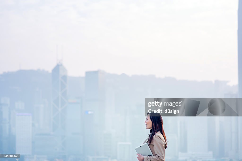 Businesswoman with digital tablet in urban city