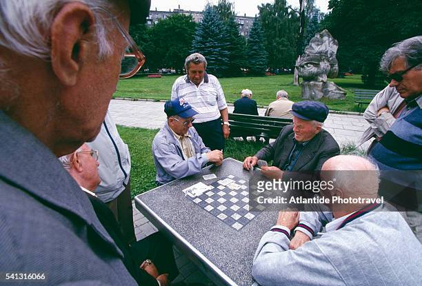 senior men playing cards - krakow park stock pictures, royalty-free photos & images